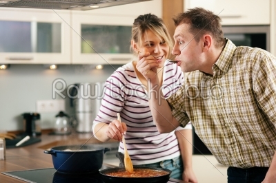 Cooking couple - tasting the sauce