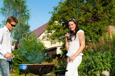 Couple doing BBQ in garden during summer