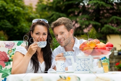 Couple drinking coffee in their garden