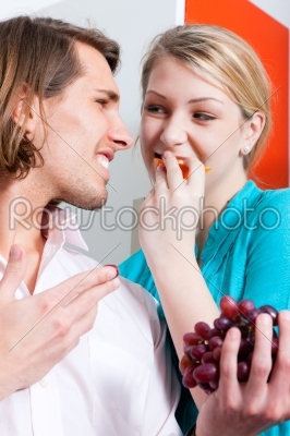 Couple eating grapes at home