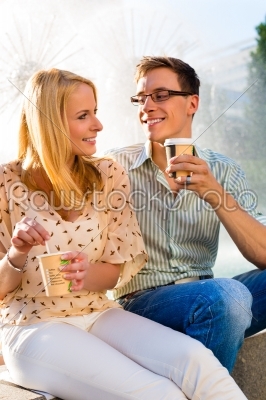 Couple enjoying take away coffee in a break