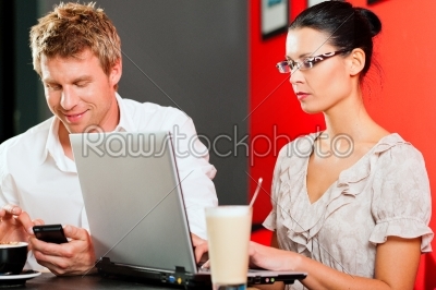 Couple in coffeeshop with laptop and mobile
