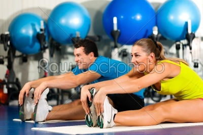 Couple in gym stretching