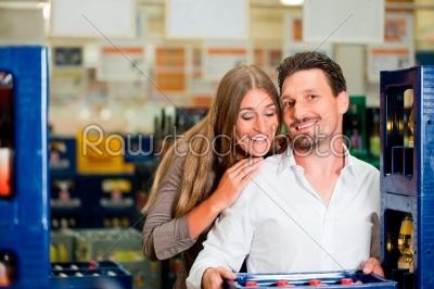 Couple in supermarket buying beverages