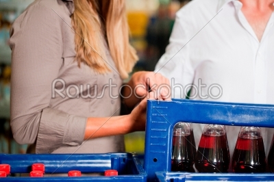 Couple in supermarket buying beverages