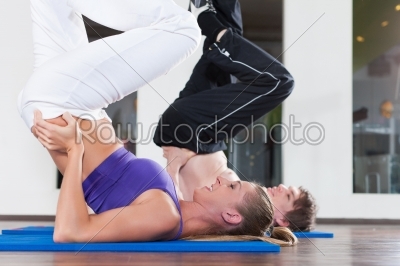 Couple is doing gymnastics in gym