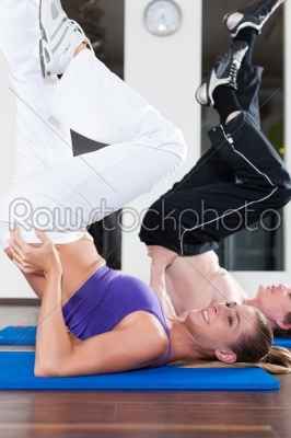Couple is doing gymnastics in gym