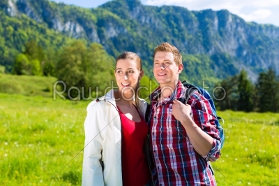 Couple is walking in the meadow with mountain