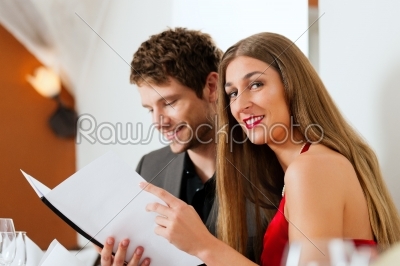 Couple looking into menu of restaurant