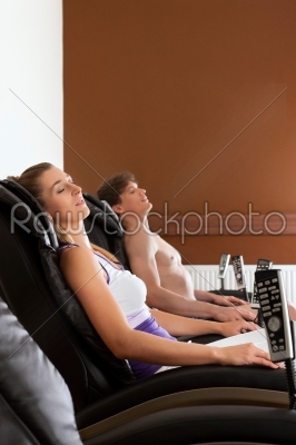 Couple on massage chair in gym
