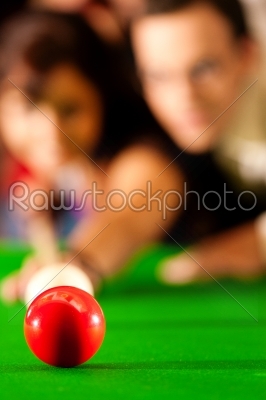 Couple playing billiards