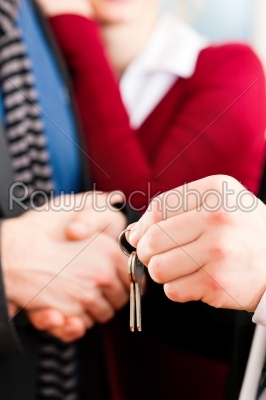 Couple receiving keys from real estate broker
