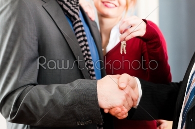 Couple receiving keys from real estate broker