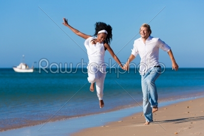 Couple walking and running on beach