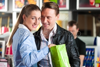 Couple with popcorn in cinema lobby