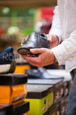 Customer Holding Stylish Shoe at Supermarket