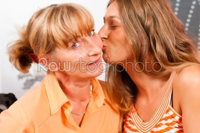 Daughter is kissing her mother as a sign of love