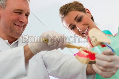 Dentist explaining teeth brushing to patient
