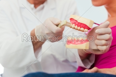 Dentist explaining teeth brushing to patient
