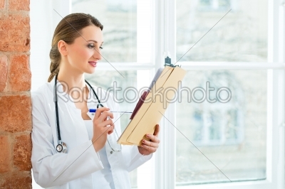 Doctor in clinic writing in a file