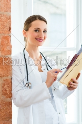 Doctor in clinic writing in a file