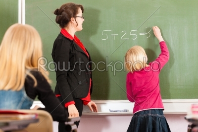 Education - teacher with pupil in school teaching