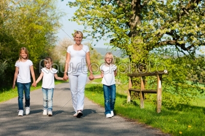 Family - kids and mother walking down a path