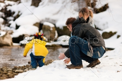 Family having winter walk at river