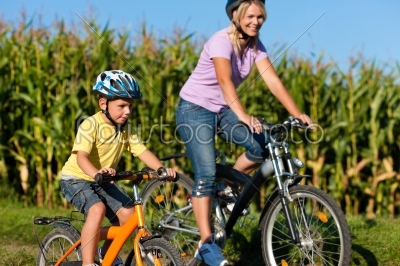 Family is cycling in summer