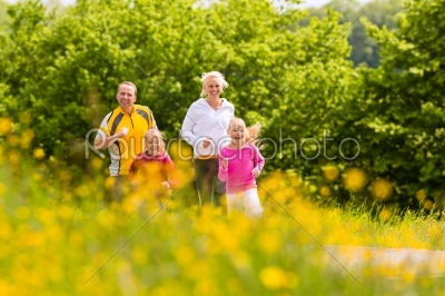 Family jogging in the meadow for fitness 