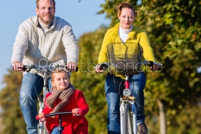 Family on bicycle tour in park