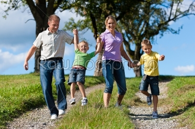 Family outdoors is running on a dirt path