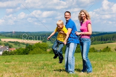 Family playing on meadow in summer