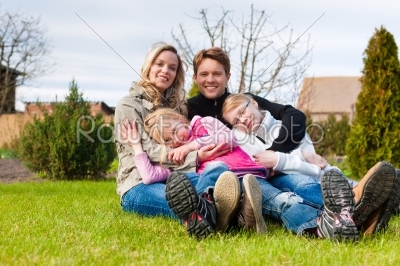 Family sitting together on a meadow in spring