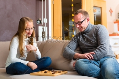 Father and daughter playing checkers