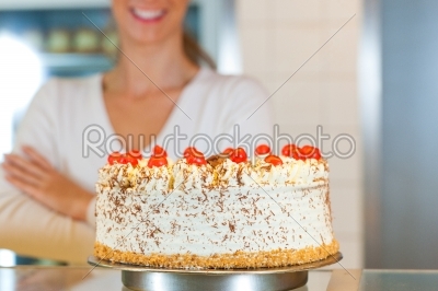 Female baker or pastry chef with torte