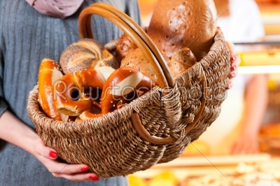 Female customer with breadbasket in bakery