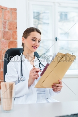 Female doctor reading in document