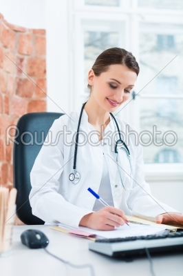 Female doctor writing in document