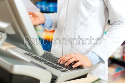 Female pharmacist at the cashier in pharmacy