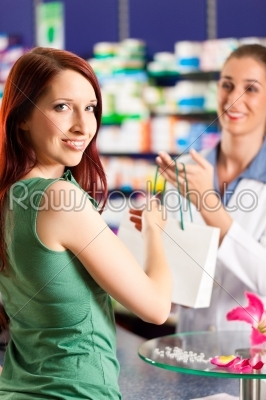 Female pharmacist in her pharmacy with a customer