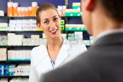 Female pharmacist with client in pharmacy