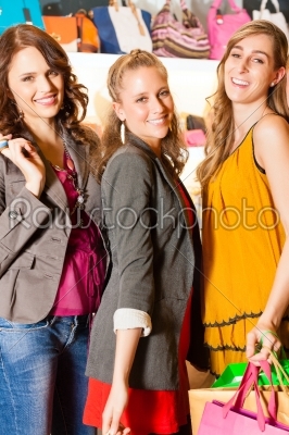 Four female friends shopping bags in a mall