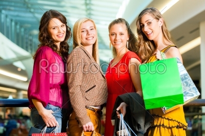 Four female friends shopping in a mall