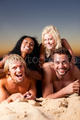 Four friends at the beach with sunset