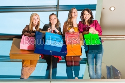 Four women friends shopping in a mall