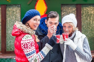 Friends drinking mulled wine on Christmas marked