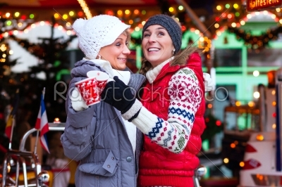 Friends drinking spiced wine on Christmas market
