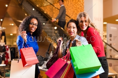 Friends shopping with presents in mall
