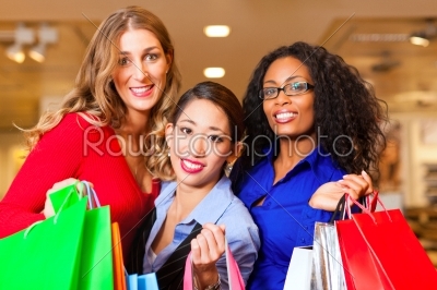 Friends shopping with presents in mall